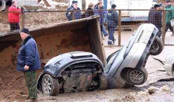 Giant pothole swallows three cars and a truck